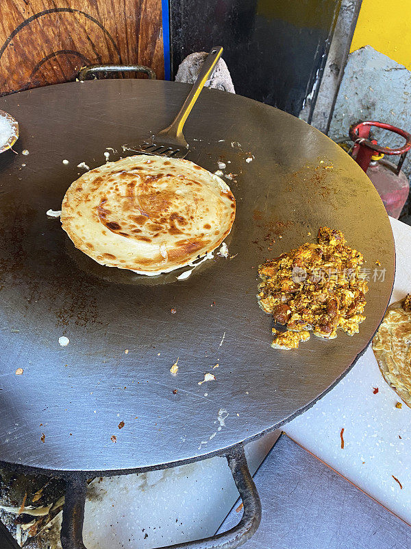 Frankie (Mumbai Burrito)街头小吃在Tawa(大而扁平的金属烹饪锅)，paratha(大饼)，paneer填充煎炸，高架视图，前景聚焦